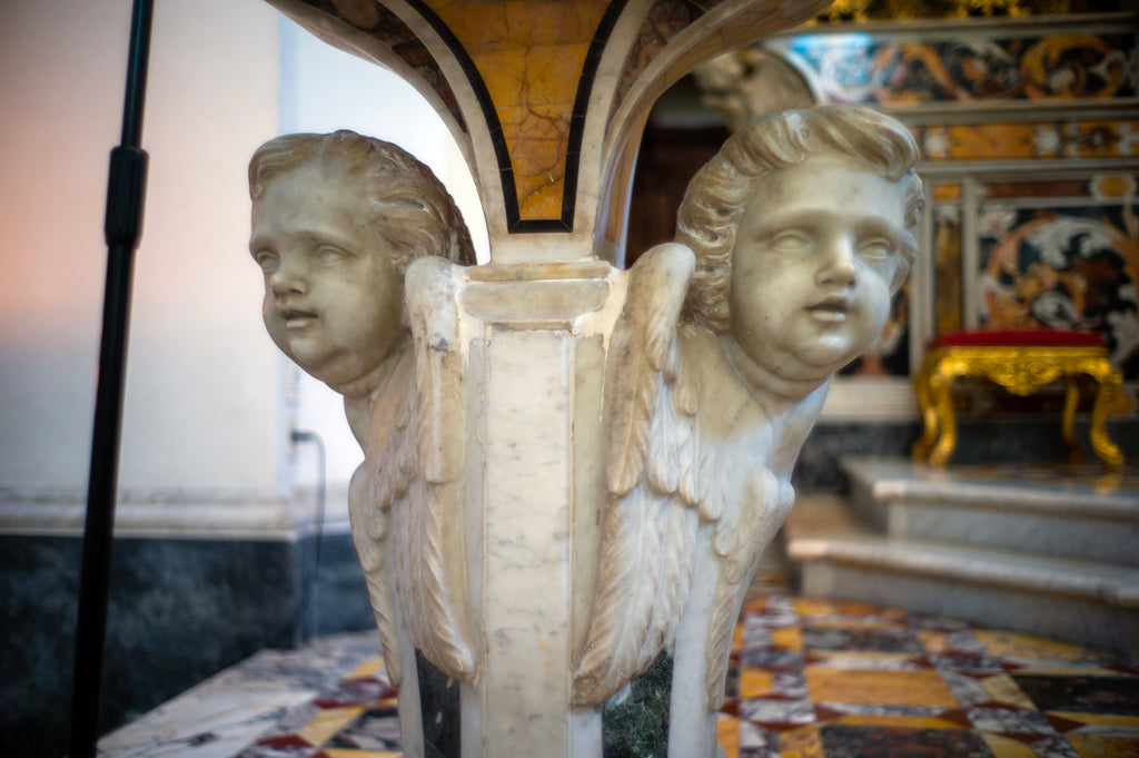 Baby angel marble sculpture on a column