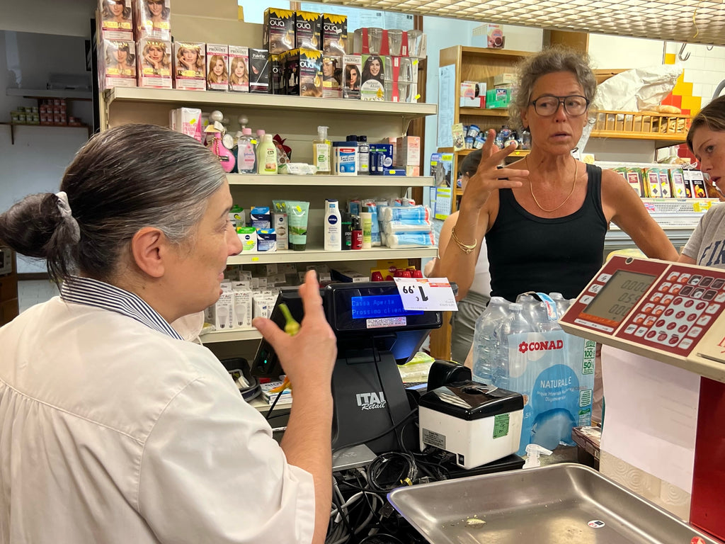 Italian cashier talking to woman