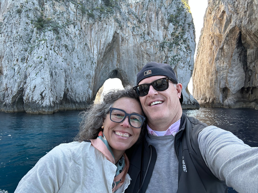 Woman and man taking selfie in front of cliffs in the ocean
