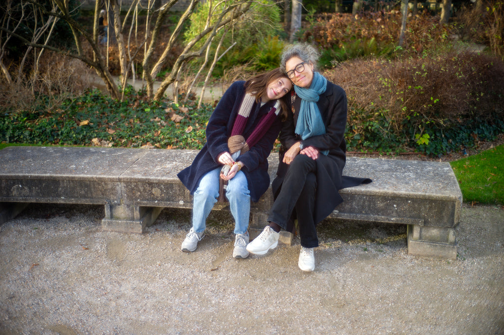 Mom and daughter sitting on a stone bench