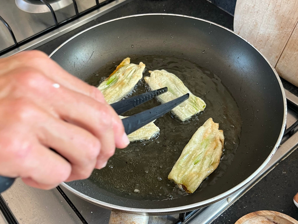 Frying flowering zucchini in a nonstick skillet with oil