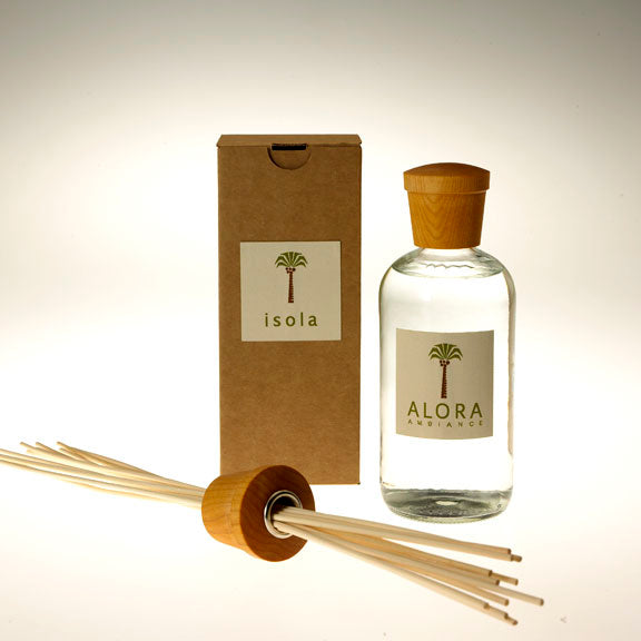 Glass Isola diffuser bottle next to brown cardboard box with palm tree on the front and the word "Isola"