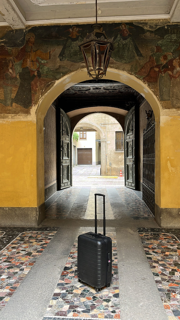 Suitcase in front of Italian archway 