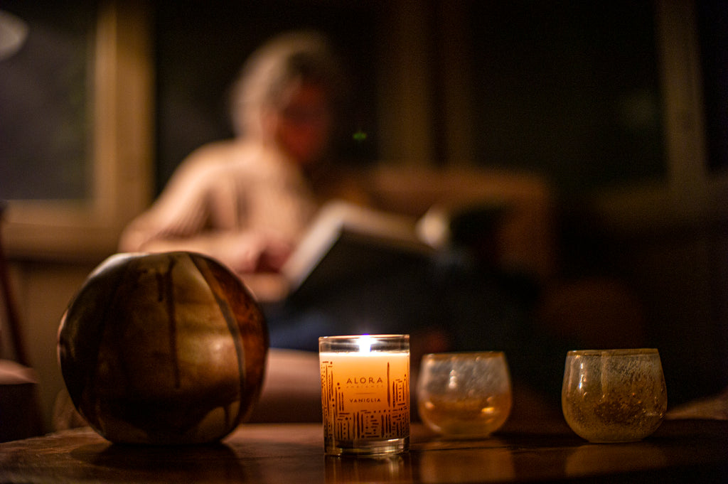 Women reading in dim light while candle burns