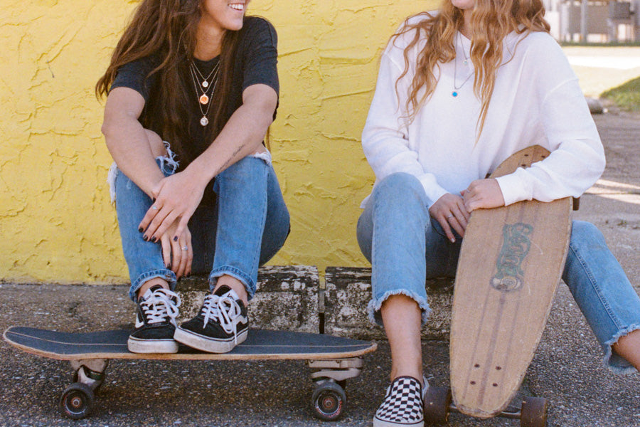 two girls with skateboards wearing best friends necklaces