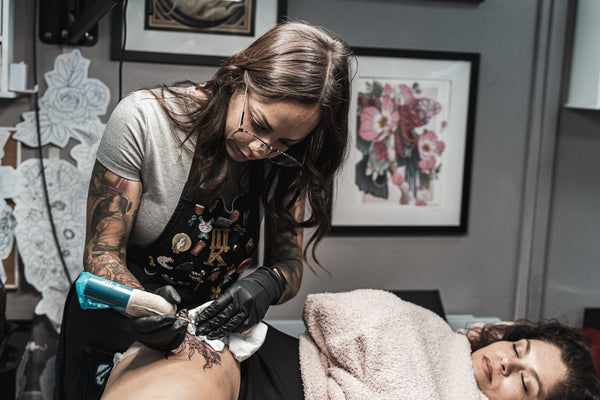 Amanda Rodriguez tattooing a customer