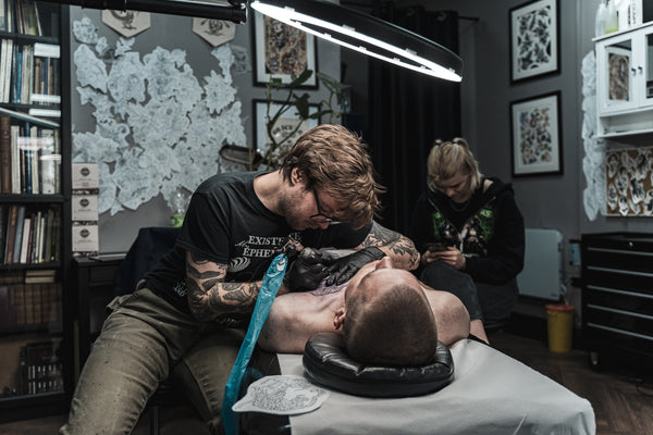 Colin Clark tattooing a customer
