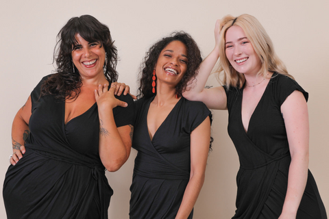 Three women wearing ethical and sustainable black wrap dresses wearwell