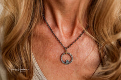 floating circle pendant in aquamarine around a woman't neck