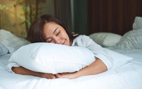 Young woman sleeping comfortably on an organic latex pillow from Rest Organic
