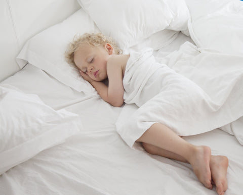 Young child sleeping on their side in bed
