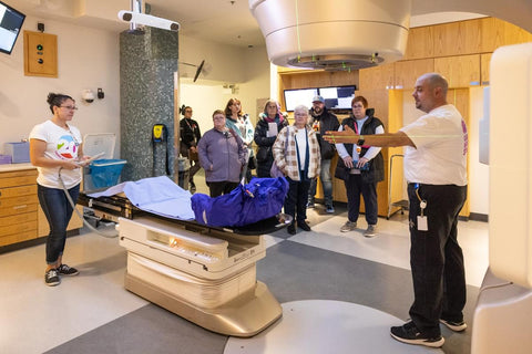 A group of open house attendees tour a radiation therapy suite with two Cancer Centre staff