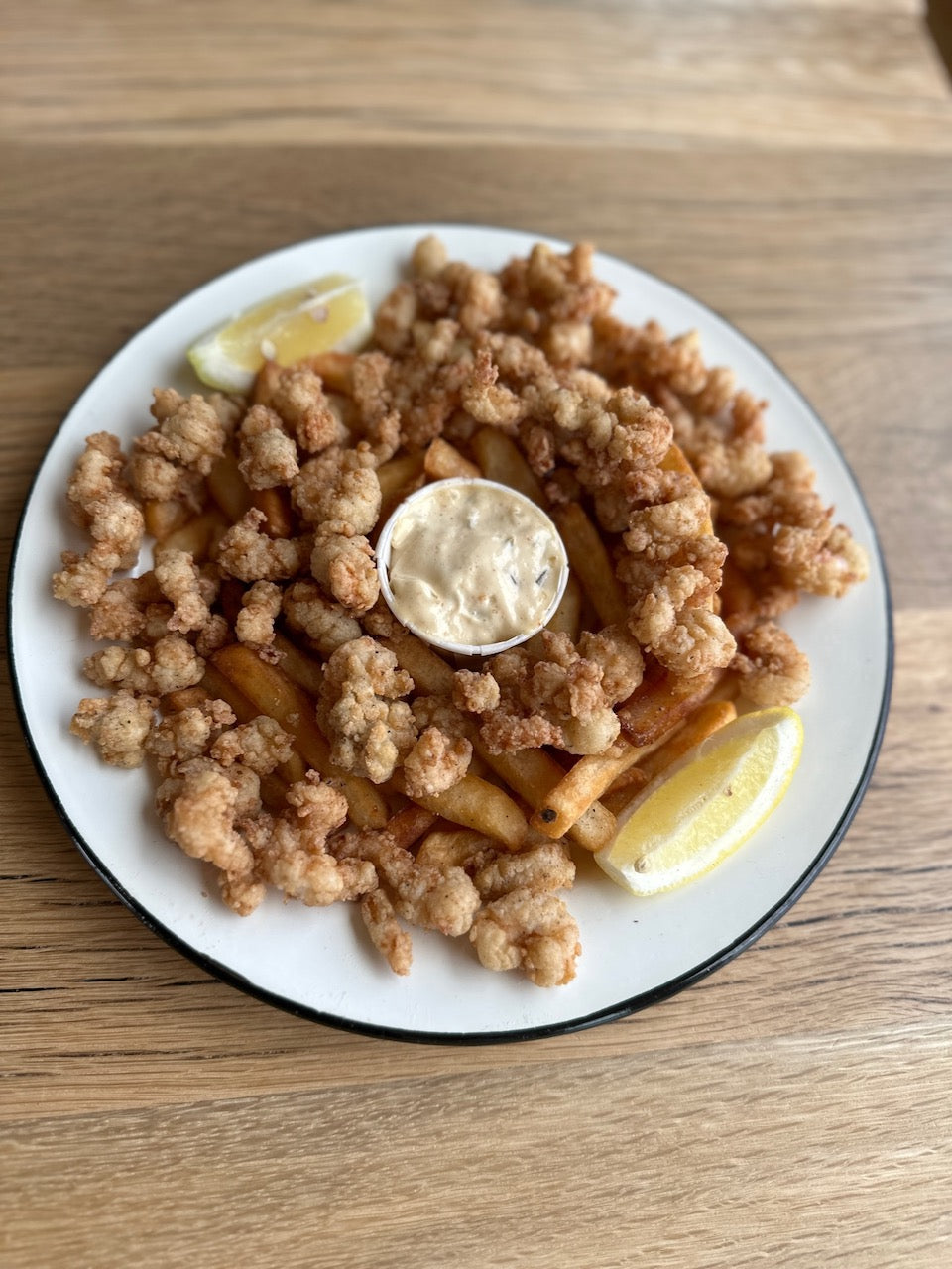 plate with fried shrimp, fries, tartar, lemon 