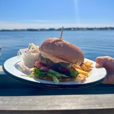 Sea veggie burger, fries, and a side of slaw on a white plate