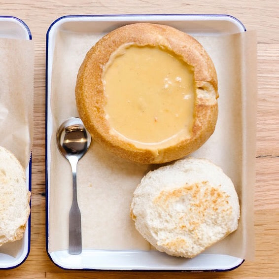 bisque in sourdough bread bowl on a white tray lined with wax paper