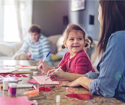 mother and daughter making valentines day cards