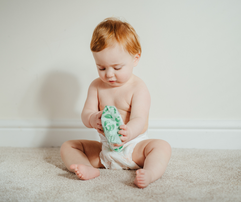 Baby holding a pack of eco baby wipes