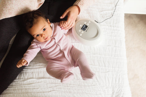 Baby on bed with breast pump