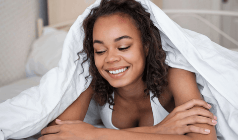 black girl with curly hair in bed