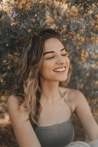 A happy and healthy woman wearing sustainable clothing