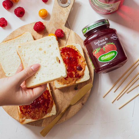 Recouvrez deux tartines d’une couche de beurre de cacahuètes et d’une couche de confiture de fraises Materne.