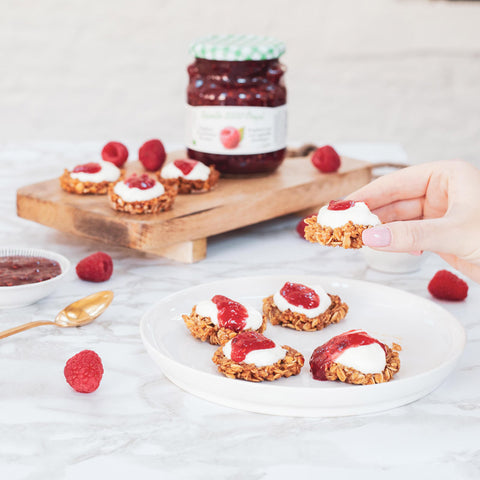 Verwarm de oven voor op 180°C en zet alvast 6 cupcakevormpjes klaar. Meng de havermout met de honing en 1 opgeklopt eiwit. Bekleed  de cupcakevormpjes met het havermoutmengsel. Bak de granola cups in 10 à 15 minuten af en laat even afkoelen. Lepel eerst wat Oogst rode aalbessenconfituur in de granola cups en bedek met yoghurt. Werk af met wat fruit naar keuze.