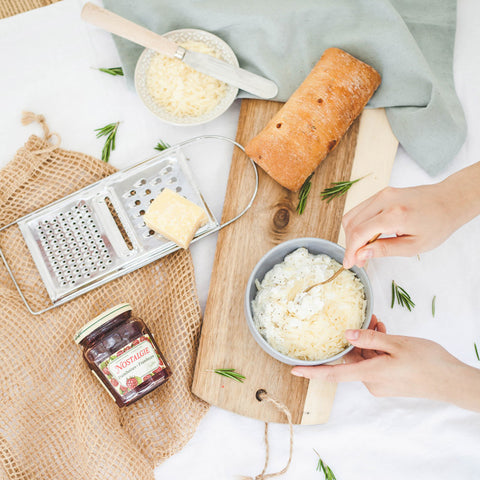 Rasp twee derde van de kaas en meng door de ricotta. Breng op smaak met peper en zout.