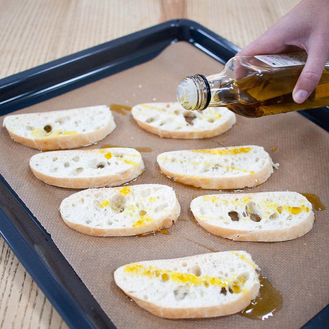 Préchauffez le four à 200°. Coupez les extrémités de la ciabatta, puis coupez celle-ci en 10 tranches diagonales. Badigeonnez le haut des tranches d'huile d'olive et faites-les griller 8 minutes au four.
