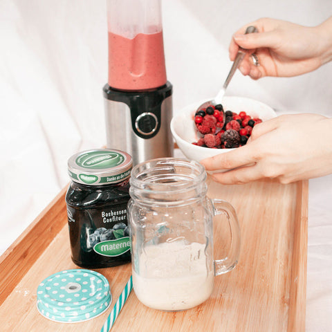 Schenk een laagje van de bananensmoothie in het glas. Zet de kan terug op de blender en voeg de resterende banaan, een handje bosvruchten en 100 milliliter volle kwark toe. Blend goed door totdat er een mooie roze kleur ontstaat. Schenk dit roze mengsel voorzichtig over de bananensmoothie.