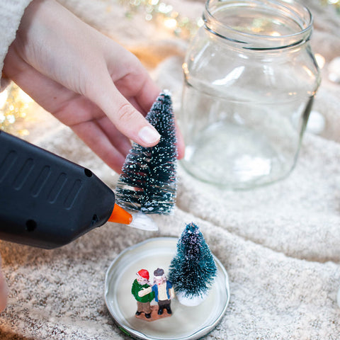 Lijn met een lijmpistool jouw mini-kerstboom, of ander attribuut, aan de binnenkant van het deksel.