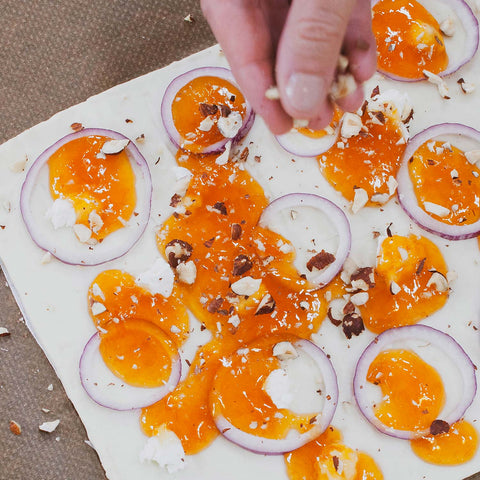 Éparpillez les noisettes concassées sur la Pi-zza et faites-la cuire pendant 15 minutes dans un four préchauffé à 200 degrés.