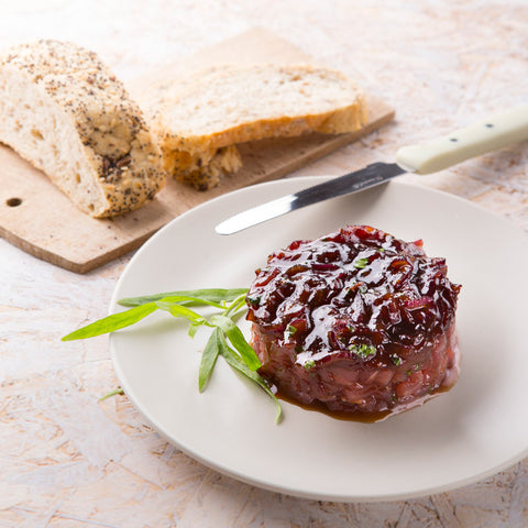 Pelez et coupez l’oignon rouge en fines rondelles. Faites revenir l’oignon dans l’huile d’olive jusqu’à ce qu’il devienne transparent, sans colorer. Mélangez la confiture et assaisonnez avec la sauce soja. Faites confire pendant 15 min. à feu doux et à couvert. Retirez du feu et laissez tiédir, finissez avec l’estragon finement haché. Présentation : dressez le tartare de thon et disposez dessus l’oignon et la confiture de fraises et de rhubarbe. Servez avec de la ciabatta, de la foccacia ou du pain naan.