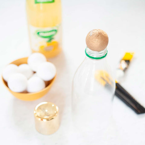 Fixez la boule sur le haut de la bouteille avec de la colle à prise rapide et laissez sécher. 