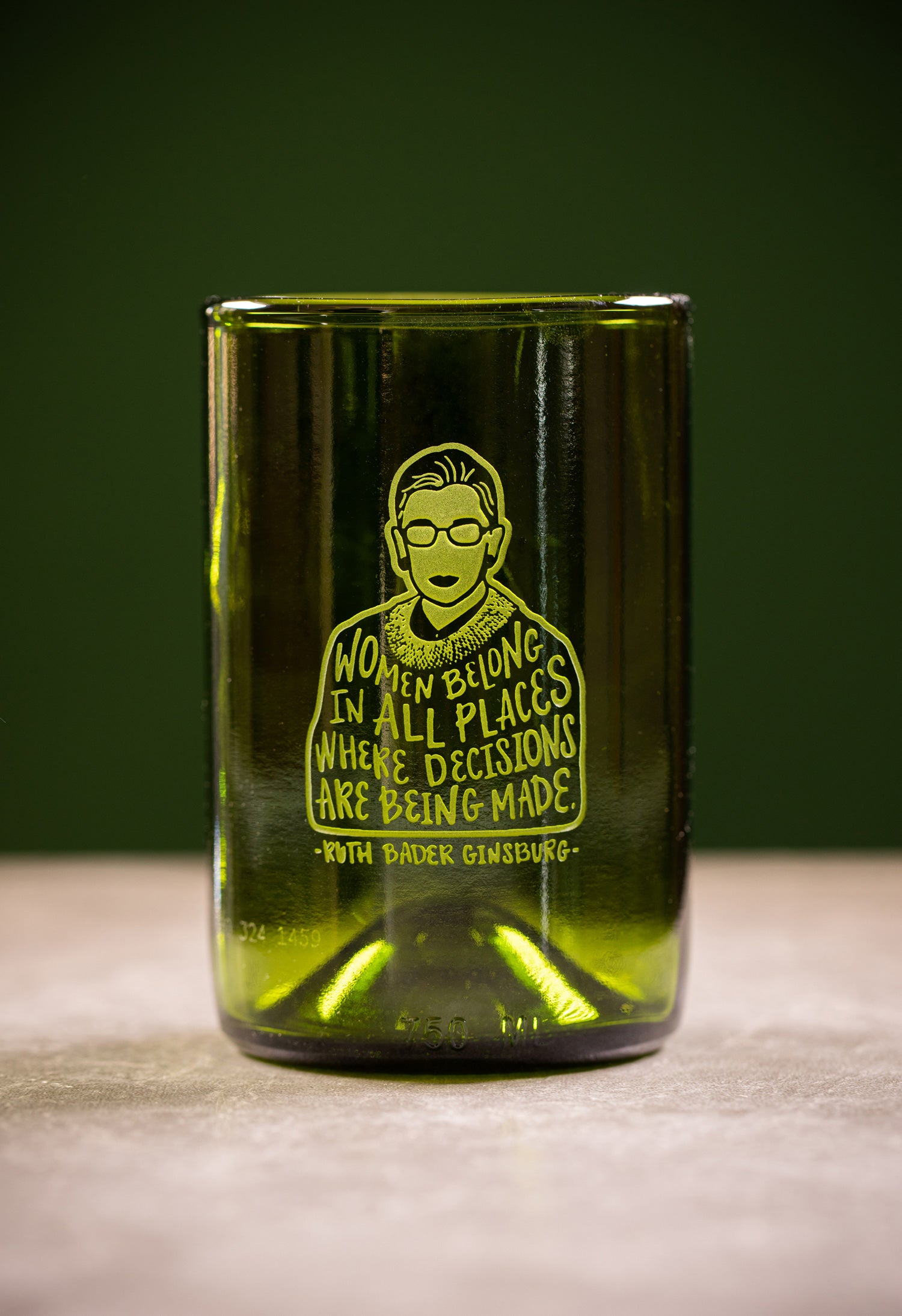 Green glass wine tumbler made from recycled green wine bottle; front of glass features etched illustration of Ruth Bader Ginsburg