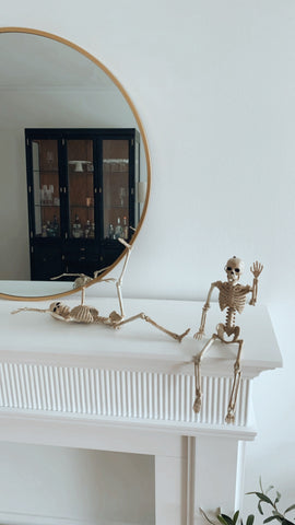 two small skeletons posed on a mantel