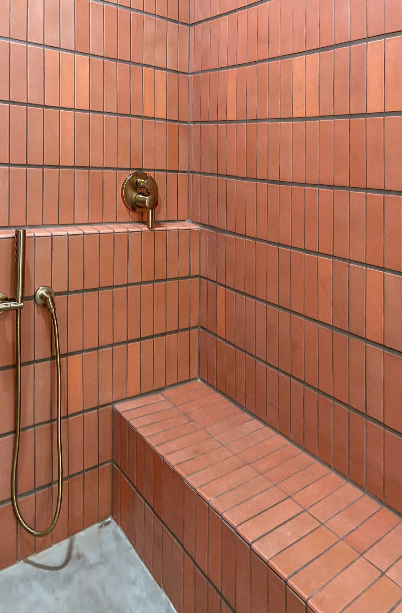 Bathroom walk in shower seat with red tile wall clay imports