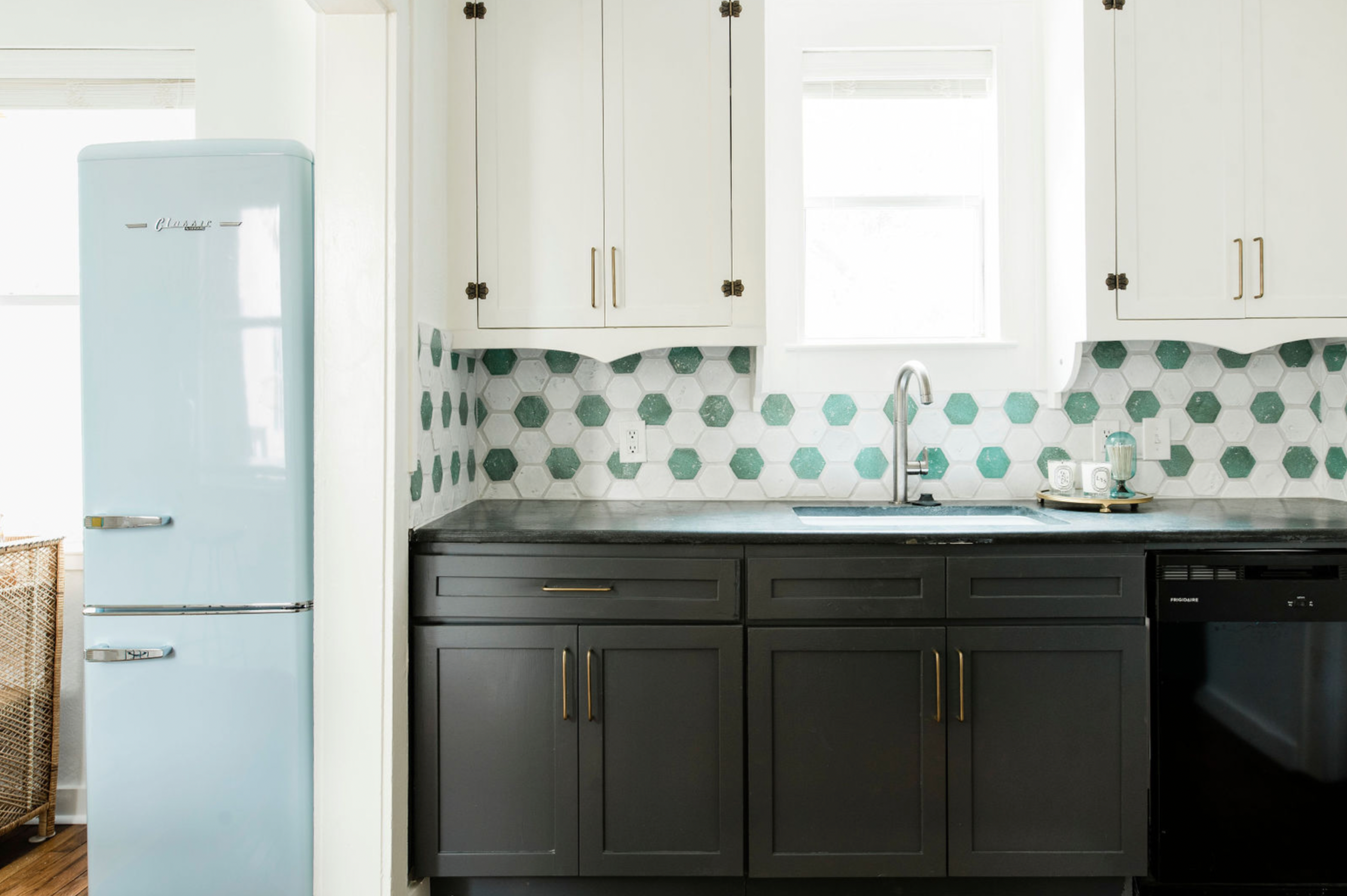 Kitchen with blue fridge, white cabinets and white and green backsplash tile clay imports
