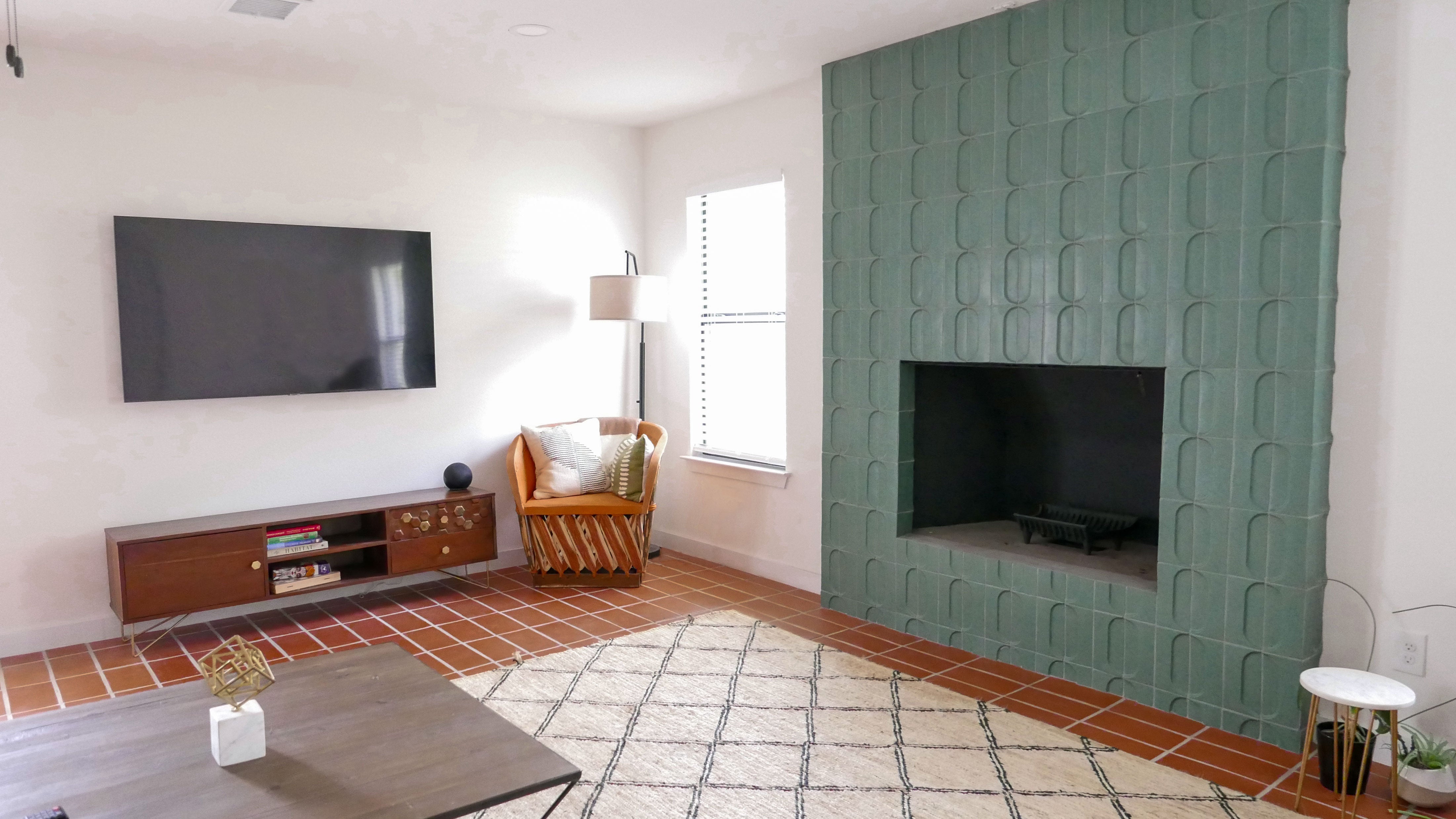 Living room at clay casa with green fireplace tile and dhanis terracotta floor by clay imports