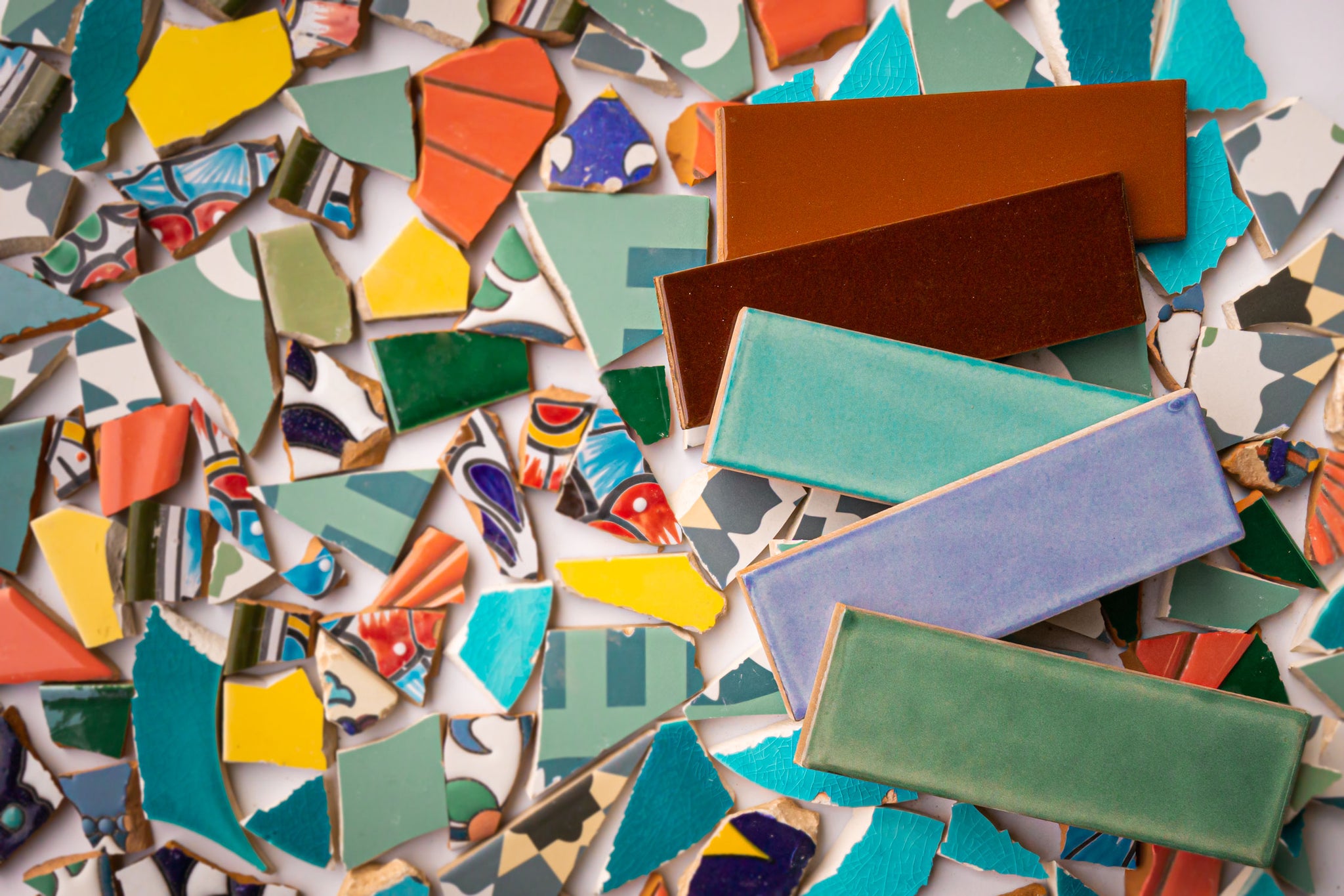 Colored tiles with tile scraps used to make recycled tiles by Clay Imports