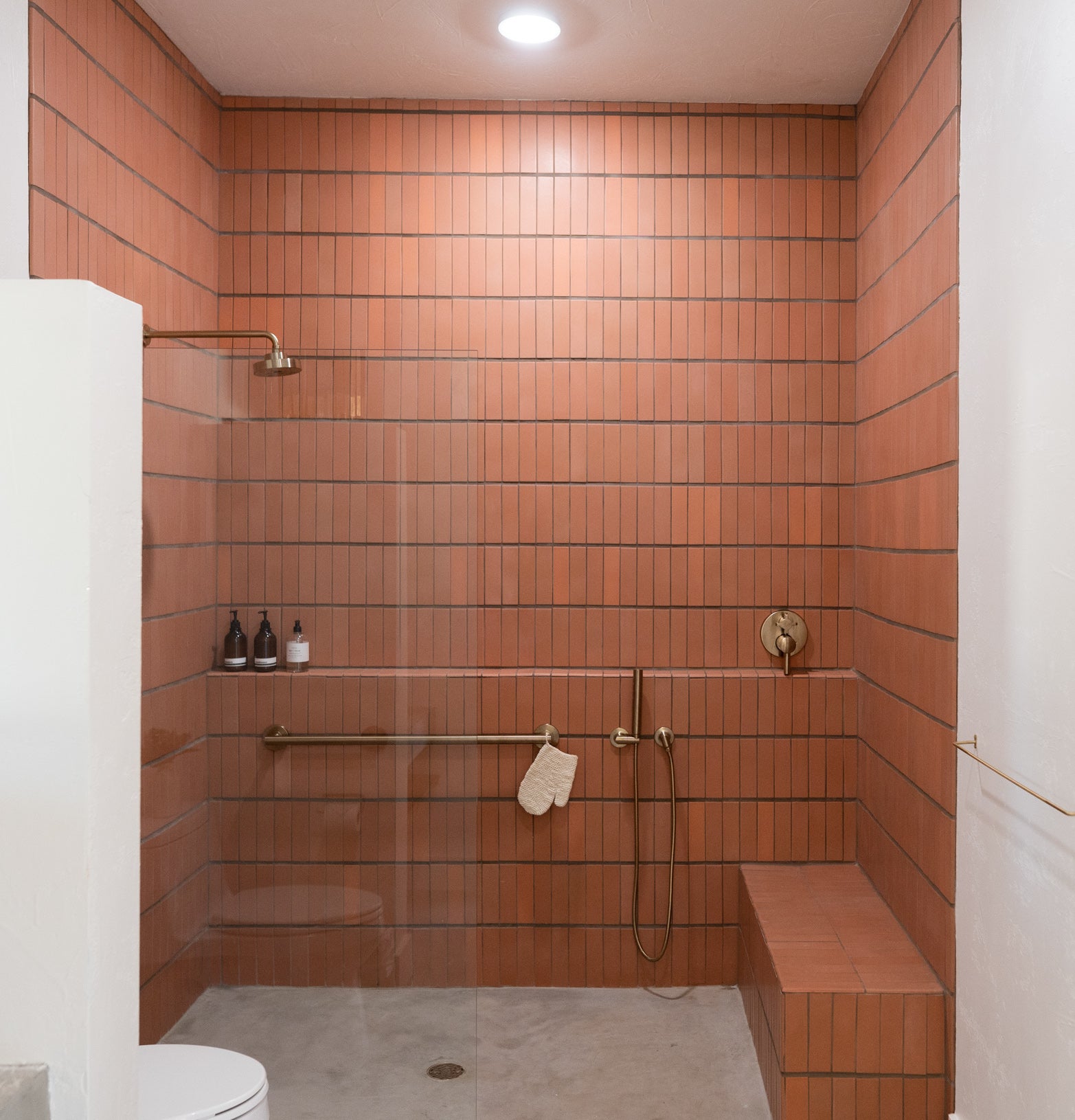 Bathroom walk in shower with red tile wall clay imports