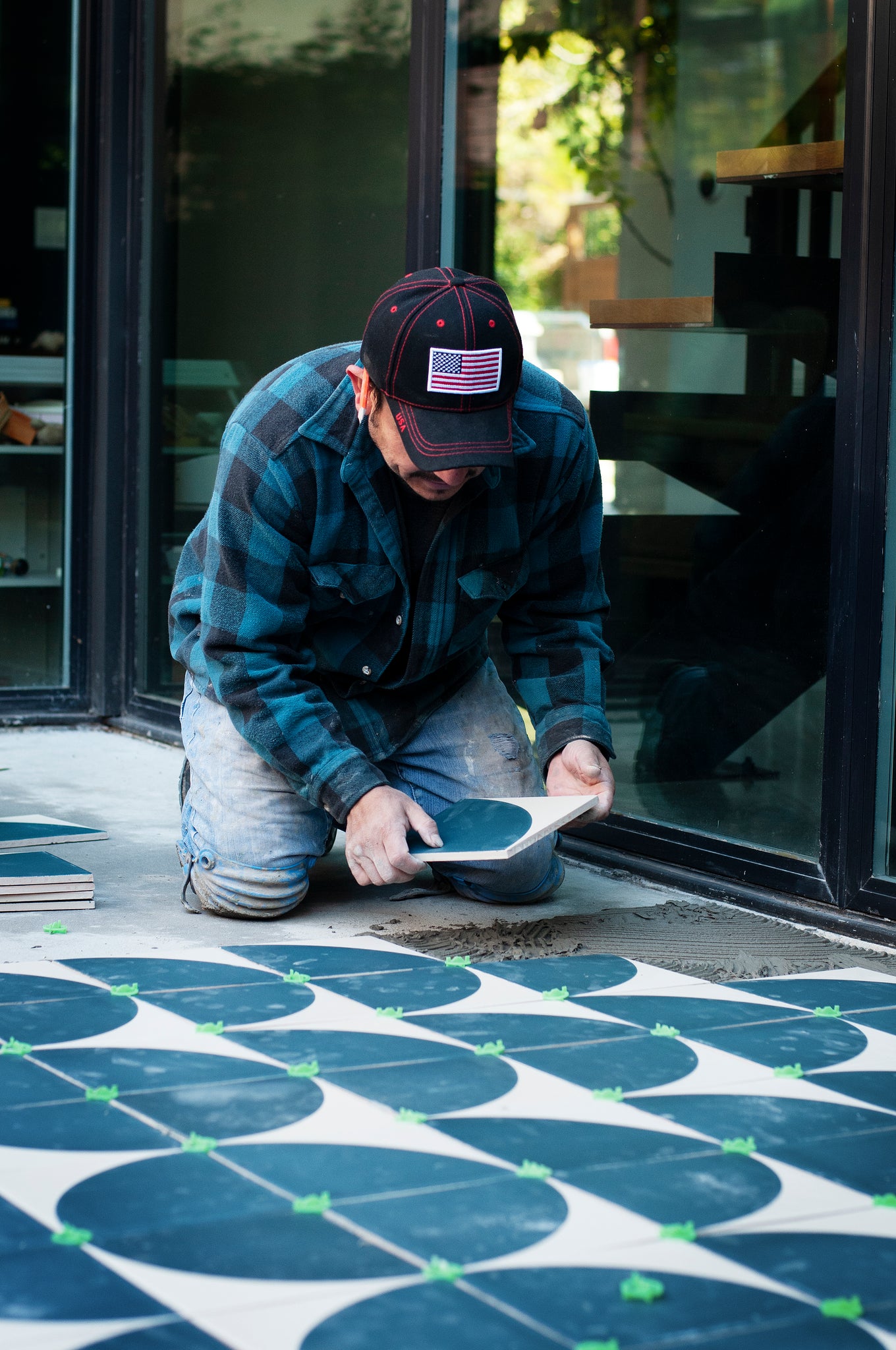 Tile installer laying tile on a subsurface