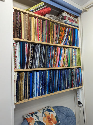 shelves with fabric stored upright like books