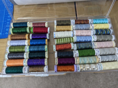 A Ferrero Rocher chocolates box, now full of many reels of coloured threads.