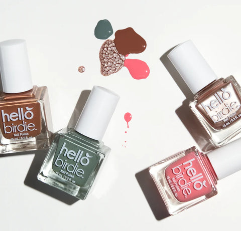 Hello Birdie classic polish bottles laid across a white background with swatches of color