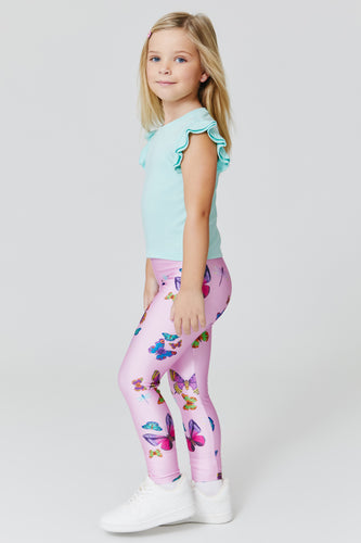 A little girl in a white shirt and pink leggings photo – Free