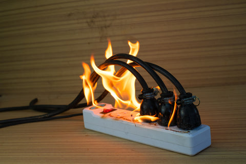fire-multisocket-with-connected-power-strip-with-bunch-plugs-wood-background 