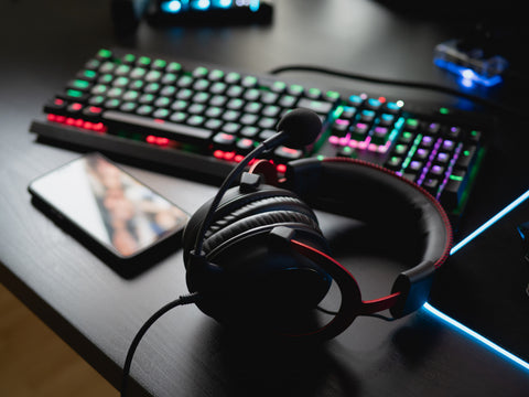 play-from-home-concept-top-view-gaming-gear-mouse-keyboard-joystick-headset-mobile-joystick-ear-headphone-mouse-pad-black-table-background-with-copy-space