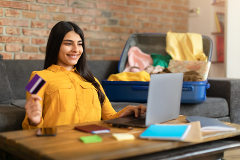 woman on laptop with credit card in hand