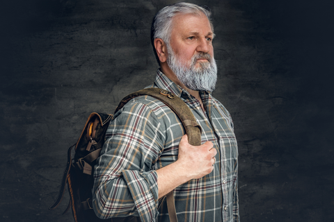 elderly man carrying a backpack in a plaid shirt