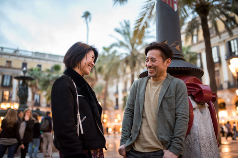 Asian man and woman talking and laughing in public place